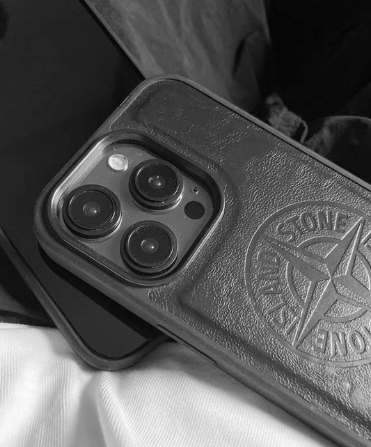 Black smartphone in Stone Island leather case with embossed logo, close-up on fabric