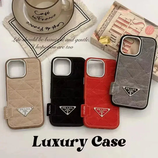 Luxury quilted Prada phone cases in beige, black, red, and grey on a white surface