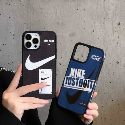 Nike Just Do It iPhone cases in black and blue held against a concrete wall
