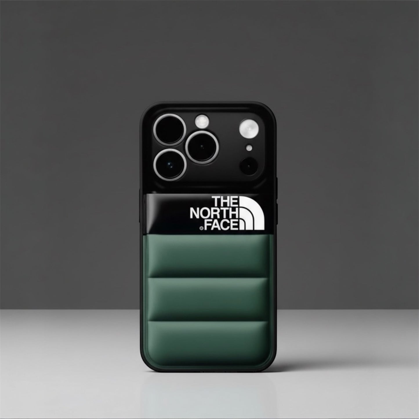 The North Face padded green iPhone case with logo, on a gray background