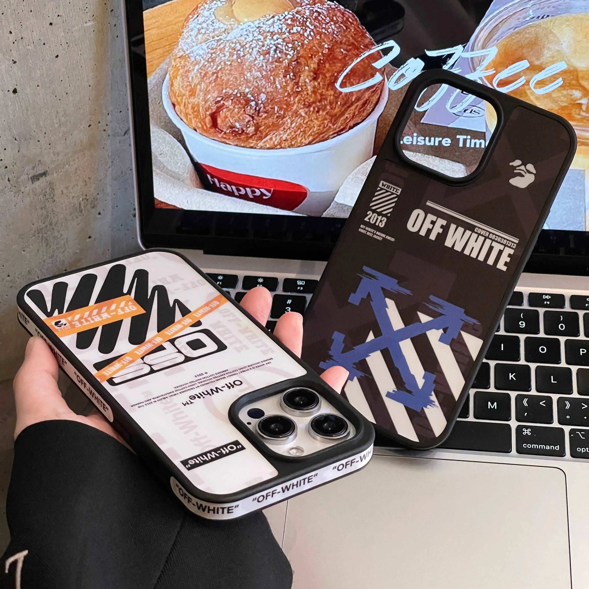 Off-White logo iPhone cases with graphic designs held over a laptop on a desk