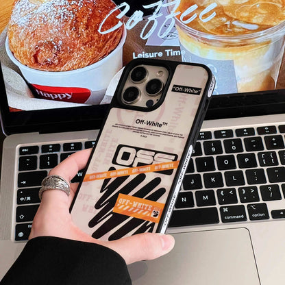 Hand holding iPhone with Off-White logo case over laptop and coffee background