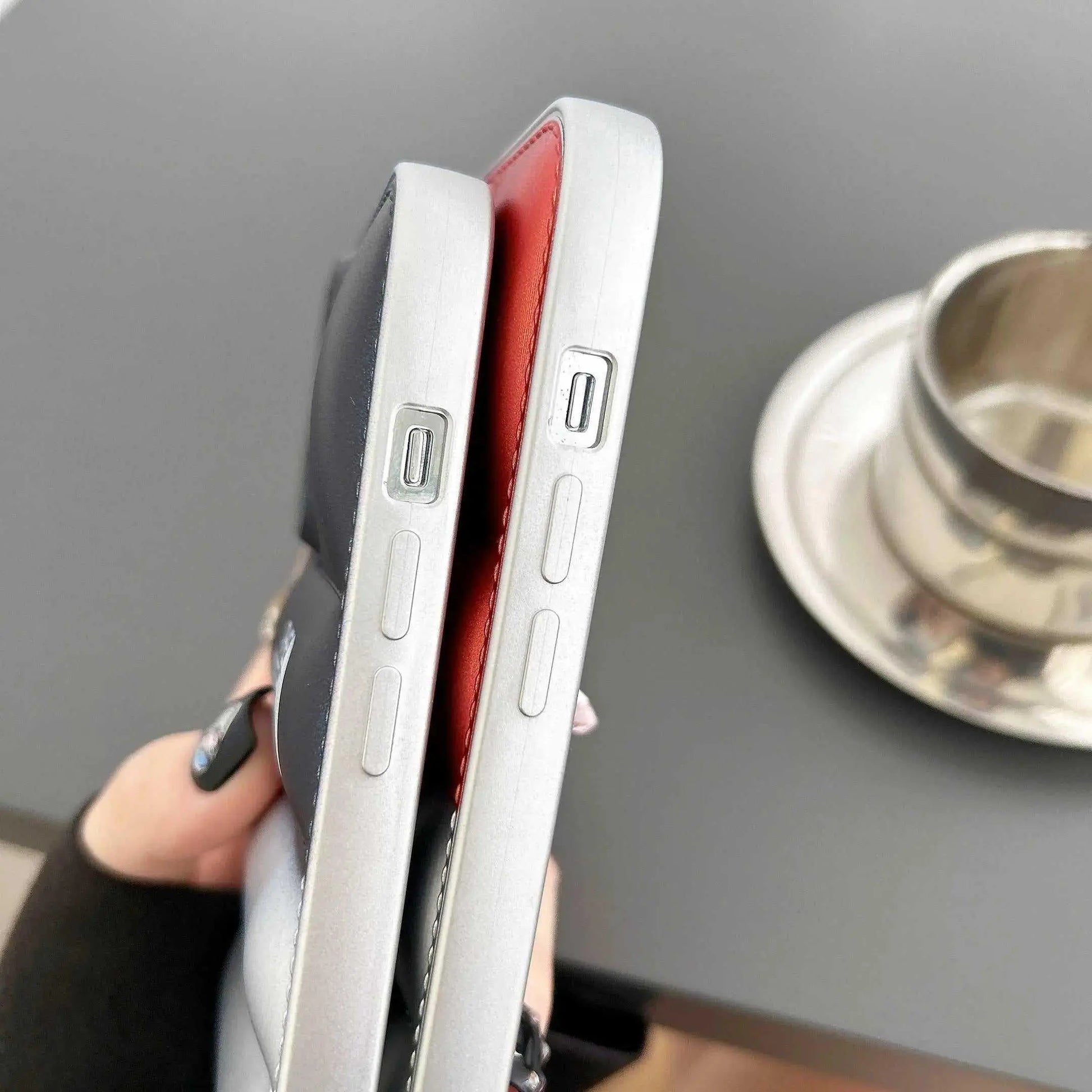 Close-up of two iPhones with black and red soft gomma cases, USB-C port visible