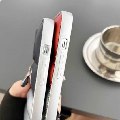 Close-up of two iPhones with black and red soft gomma cases, USB-C port visible